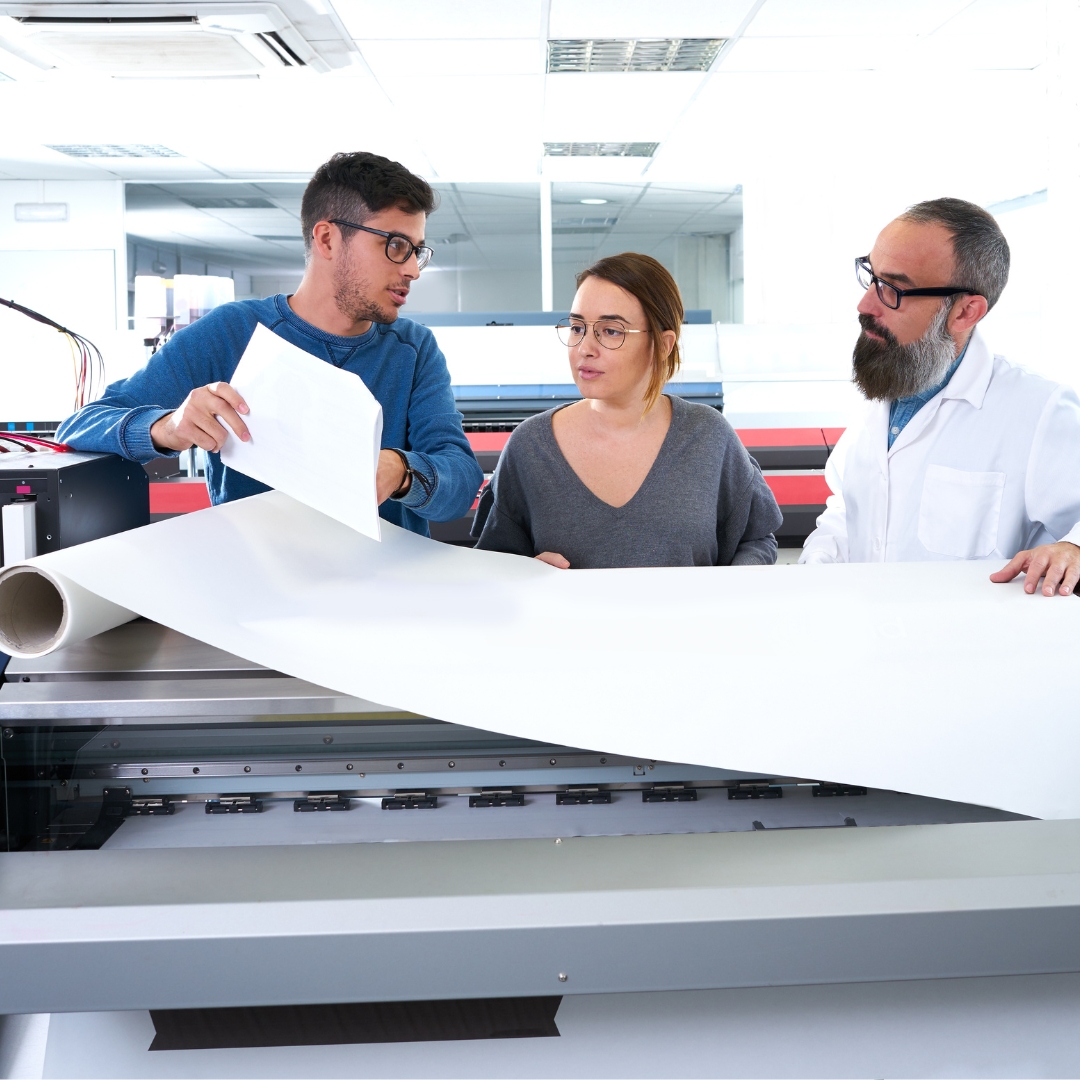 group of printers working together on a large banner
